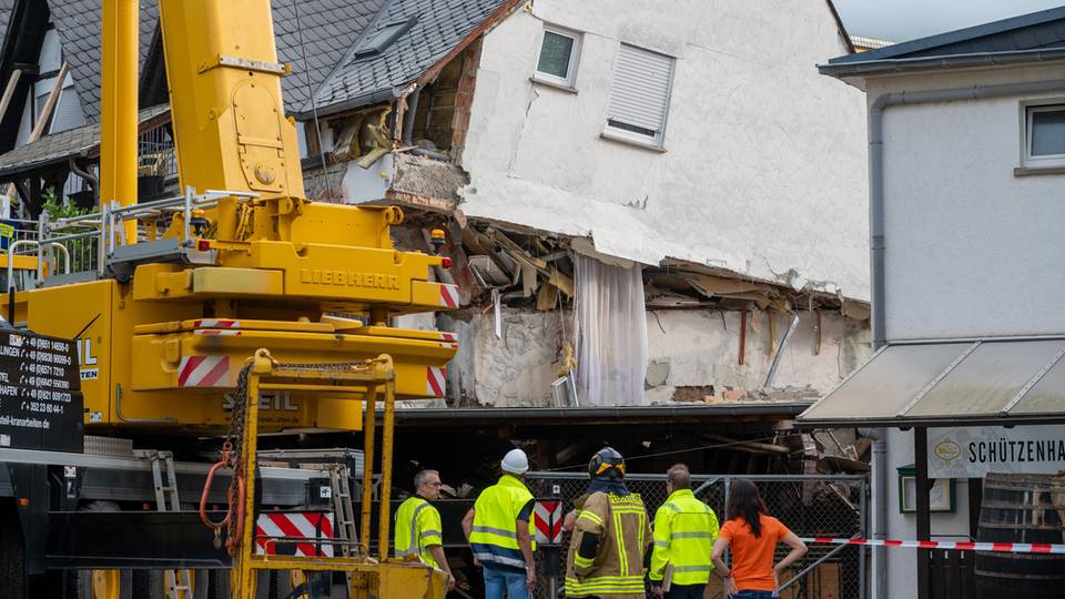 Zusammengesackt: Einsatzkräfte begutachten den Schaden an dem Hotel in der Gemeinde Traben-Trarbach