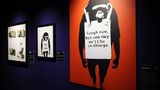 Der Planet der Affen  Was sehen wir? 2002 sprayte Banksy diesen sinister dreinblickenden Schimpansen zum ersten Mal in Brighton auf eine Hauswand, mit wechselnden Sprüchen wie "Keep It Real" auf der Reklametafel, die der Affe um seinen Hals trägt. Im Lauf der Jahre wurde er in seiner obigen Form zu einem der beliebtesten und bekanntesten Banksy-Motive.  Was will uns Banksy damit sagen? Diesmal ließ Banksy daran keinen Zweifel, der Schimpanse macht ja dafür Reklame. Übersetzt heißt der Slogan: "Lacht nur, aber eines Tages haben wir das Sagen."