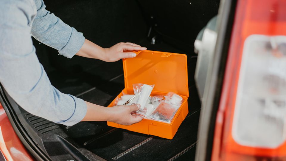 Junge Frau mit Auto Erste-Hilfe-Kit-Box