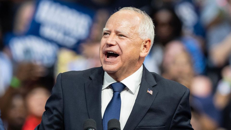 Tim Walz steht auf einem Podium.