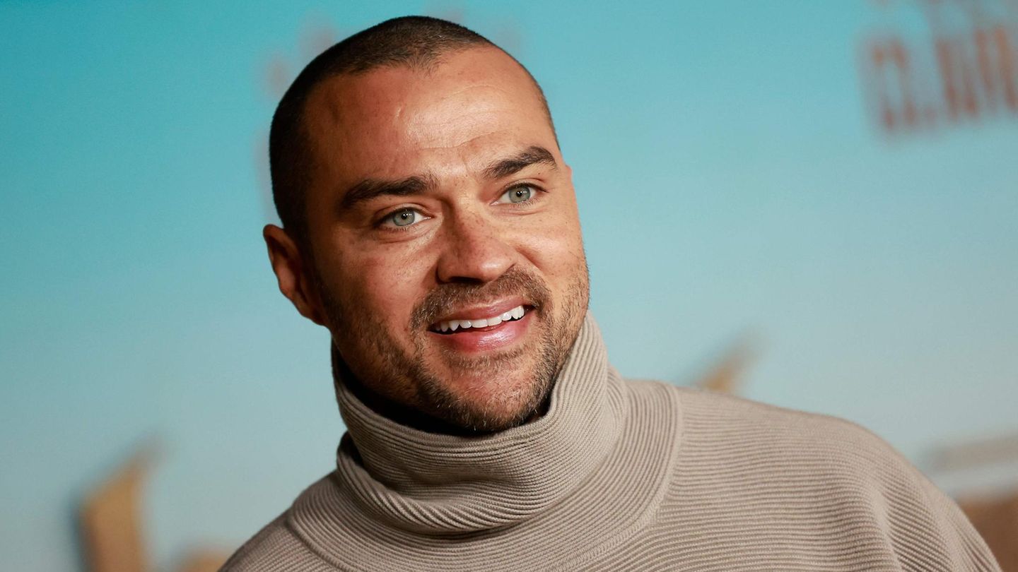 Jesse Williams schaut an der Kamera vorbei und lächelt.