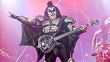 Gene Simmons steht verkleidet auf der Bühne und hält einen Bass.