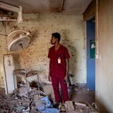 Ein Pfleger in rotem Hemd steht vor den zerstörten Überresten eines Operationsraums