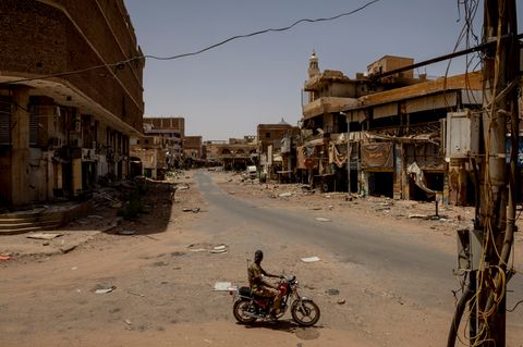 Ein einsames Motorrad in einer komplett zerstörten Straße im Sudan