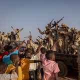 Soldaten werden von jungen Männern bejubelt.
