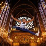 Dimitri Pavade springt, während er in der Sainte-Chapelle (Heilige Kapelle) in Paris posiert