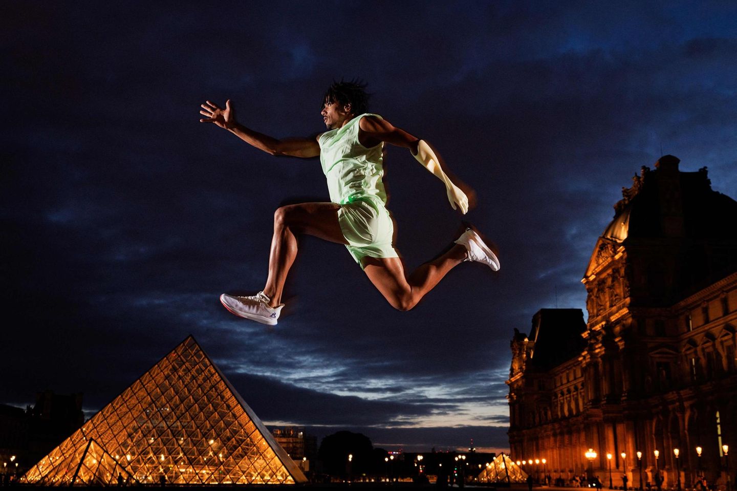 Frankreichs paralympischer Dreispringer Arnaud Assoumani posiert vor der von Ieoh Ming Pei entworfenen Louvre Pyramide in Paris