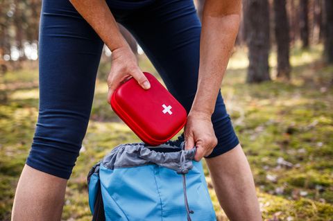 Frau nimmt Erste-Hilfe-Kasten aus dem Rucksack