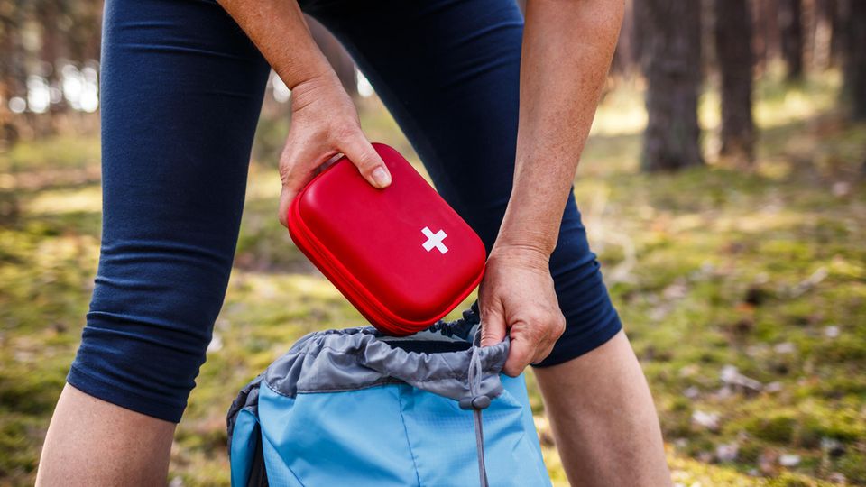 Frau nimmt Erste-Hilfe-Kasten aus dem Rucksack