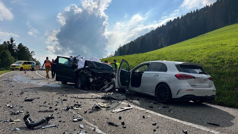 Zwei zerstörte Autos stehen nach einem Verkehrsunfall in der Schweiz am Straßenrand