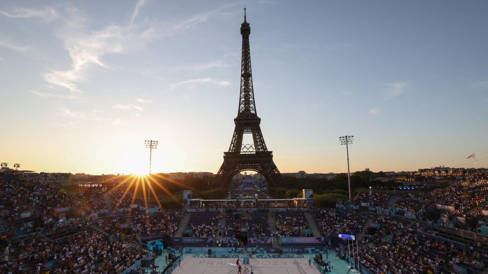 Die Sonne geht hinter der olympischen Beachvolleyballarena am Eiffelturm in Paris unter