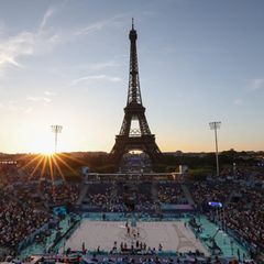 Die Sonne geht hinter der olympischen Beachvolleyballarena am Eiffelturm in Paris unter