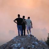 Drei Männer halten auf einer Anhöhe bei Varnavas Ausschau nach Flammen und Rauch. In der Umgebung bekämpft die Feuerwehr auf einer Fläche von rund 200 Quadratkilometern unzählige Brandherde