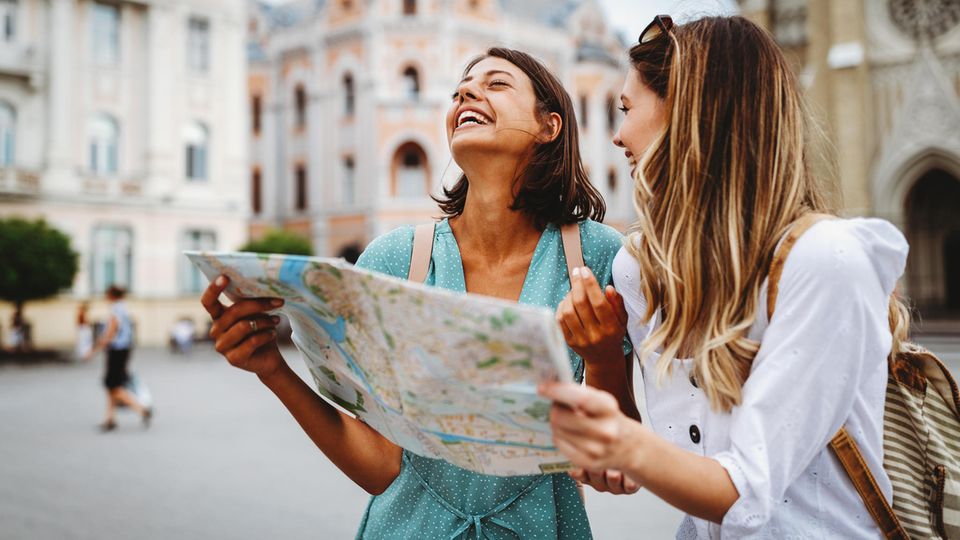 Zwei Frauen im Urlaub mit einem Stadtplan in der Hand