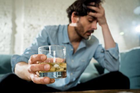 Beziehung beendet: Ein einsamer Mann trinkt Alkohol