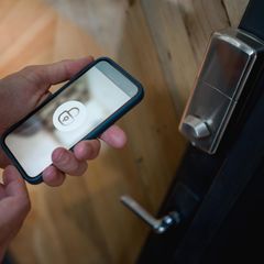 Ein Mann öffnet sein Smart Lock mit dem Smartphone