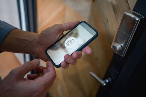 Ein Mann öffnet sein Smart Lock mit dem Smartphone