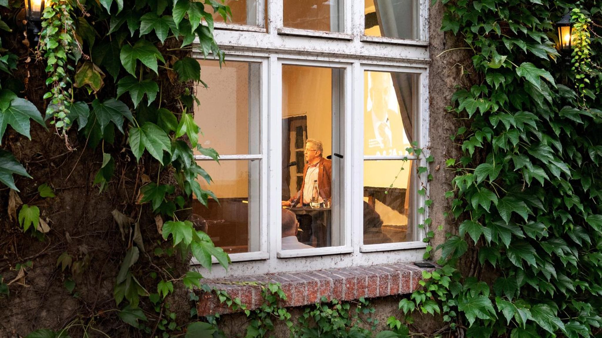 Hans-Georg Maaßen durch ein Fenster fotografiert