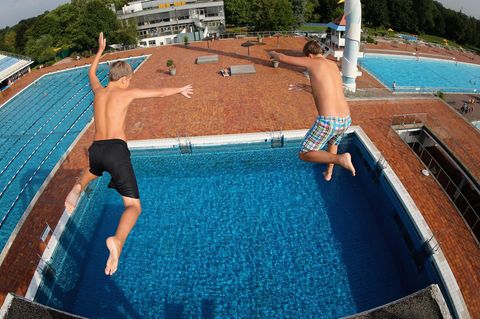 Zwei Jungs springen vom Sprungturm