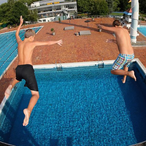Zwei Jungs springen vom Sprungturm