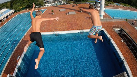 Zwei Jungs springen vom Sprungturm