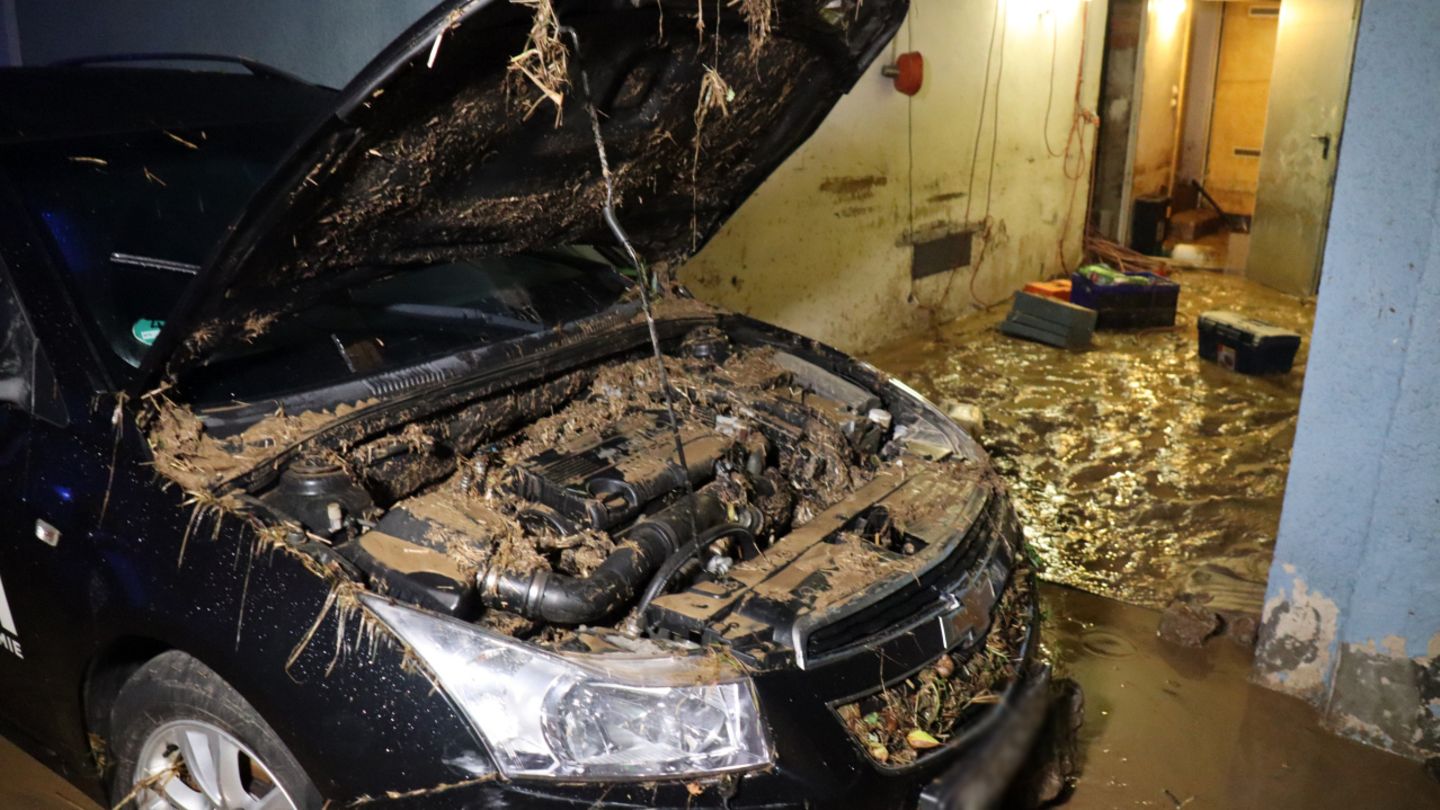 Wo das Wasser abläuft, bleibt Schlamm: Hier zu sehen in einem Hauseingang und im Motorraum eines Autos (mit offener Haube)