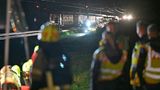 Blick über die Köpfe von Feuerwehrleuten hinweg auf den aufgefahrenen Zug