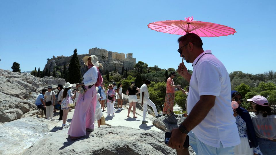 Hitze in Athen, Aufnahme vom 17.07.2024: Touristen gehen an einem heißen Tag auf dem Areopag