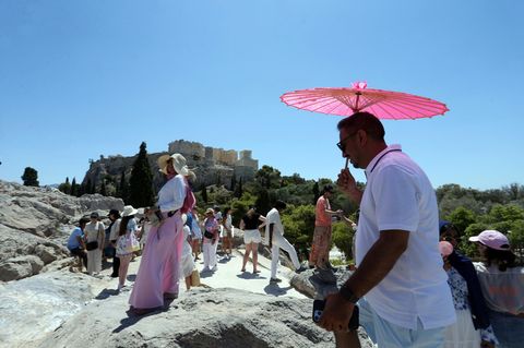 Hitze in Athen, Aufnahme vom 17.07.2024: Touristen gehen an einem heißen Tag auf dem Areopag