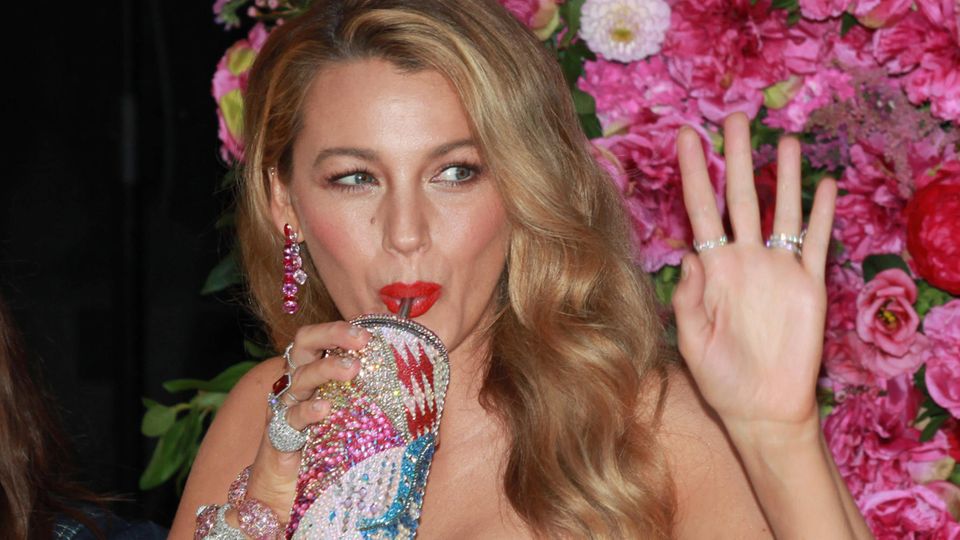 Blake Lively trinke aus einem glitzernden Becher mit Strohhalm