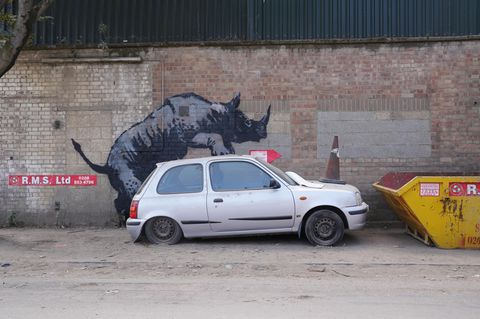 In Charlton, Südlondon, besteigt Banksys Nashorn ein altes Auto. Der Nissan Micra wurde kurz darauf entfernt, das Nashorn von einem anderen Graffiti-Künstler mit einem Tag versehen 