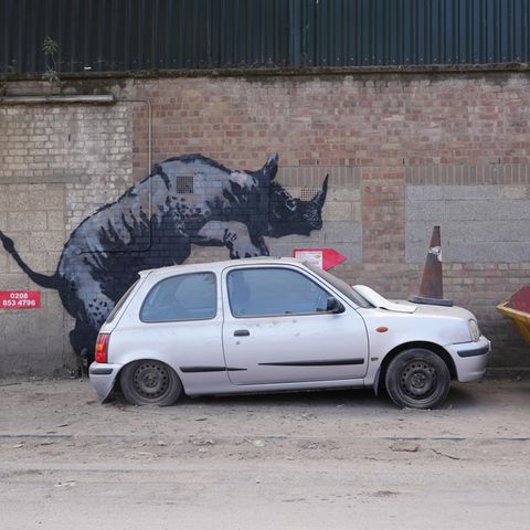 In Charlton, Südlondon, besteigt Banksys Nashorn ein altes Auto. Der Nissan Micra wurde kurz darauf entfernt, das Nashorn von einem anderen Graffiti-Künstler mit einem Tag versehen 