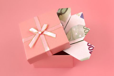 Geöffnete rosa Geschenkschachtel mit gefalteten 100 Euro Noten