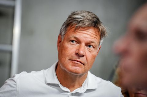 Robert Habeck schaut aus den Augenwinkeln auf jemanden, der nicht im Bild ist