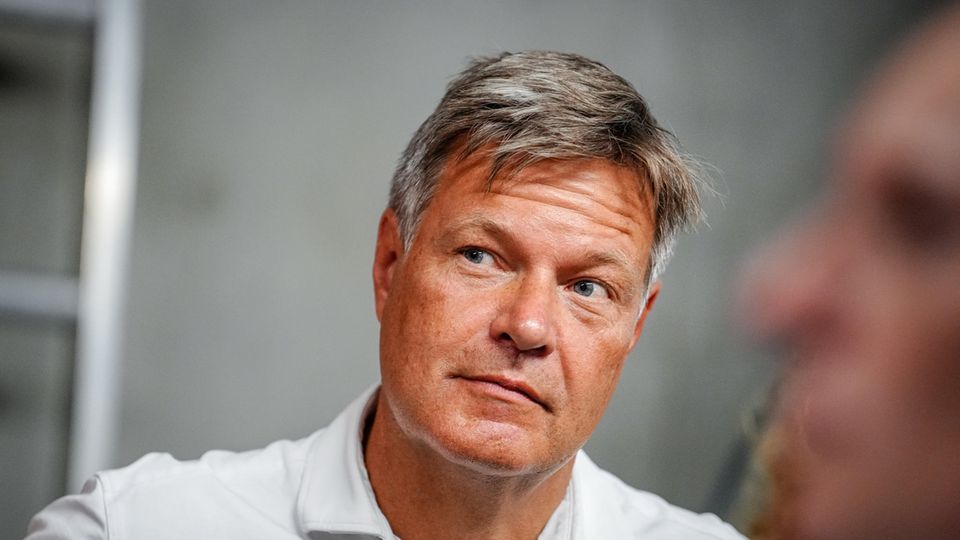 Robert Habeck schaut aus den Augenwinkeln auf jemanden, der nicht im Bild ist