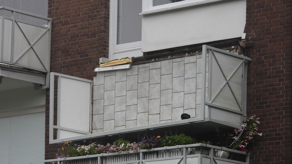 Umgeknickter Balkon hängt an der Hauswand herunter