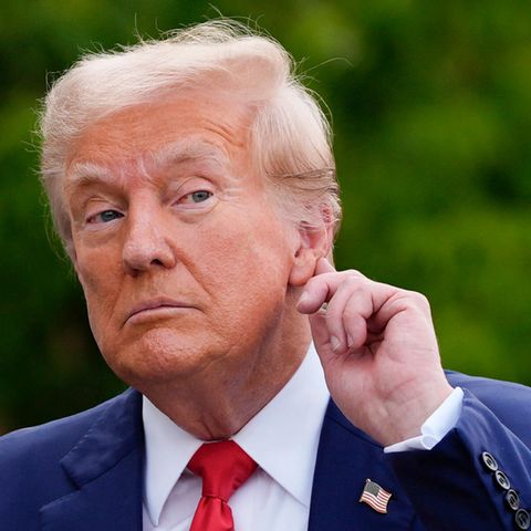 Donald Trump halt die Hand ans Ohr, so als wollte er besser hören