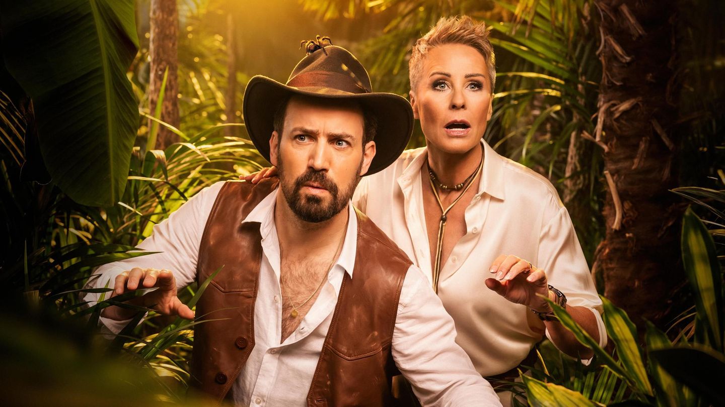 Jan Köppen und Sonja Zietlow vor einer Kulisse von Dschungelcamp Legenden
