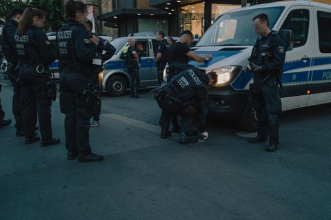 Messertaskforce: Ein junger Mann wird an einem Polizeiauto von einem Polizisten abgetastet