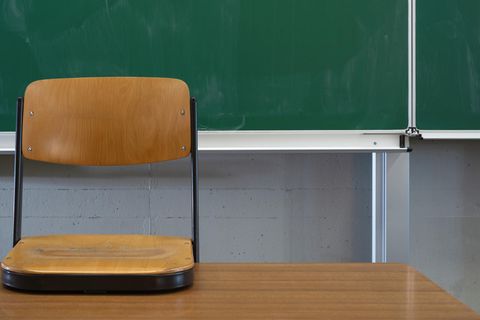 Vor einer leeren Tafel ist der Stuhl auf den Lehrertisch gestellt