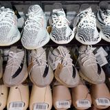 Die Yeezy-Sneaker von Kanye West stehen reihenweise im Regal eines Sportgeschäfts