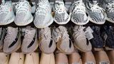 Die Yeezy-Sneaker von Kanye West stehen reihenweise im Regal eines Sportgeschäfts