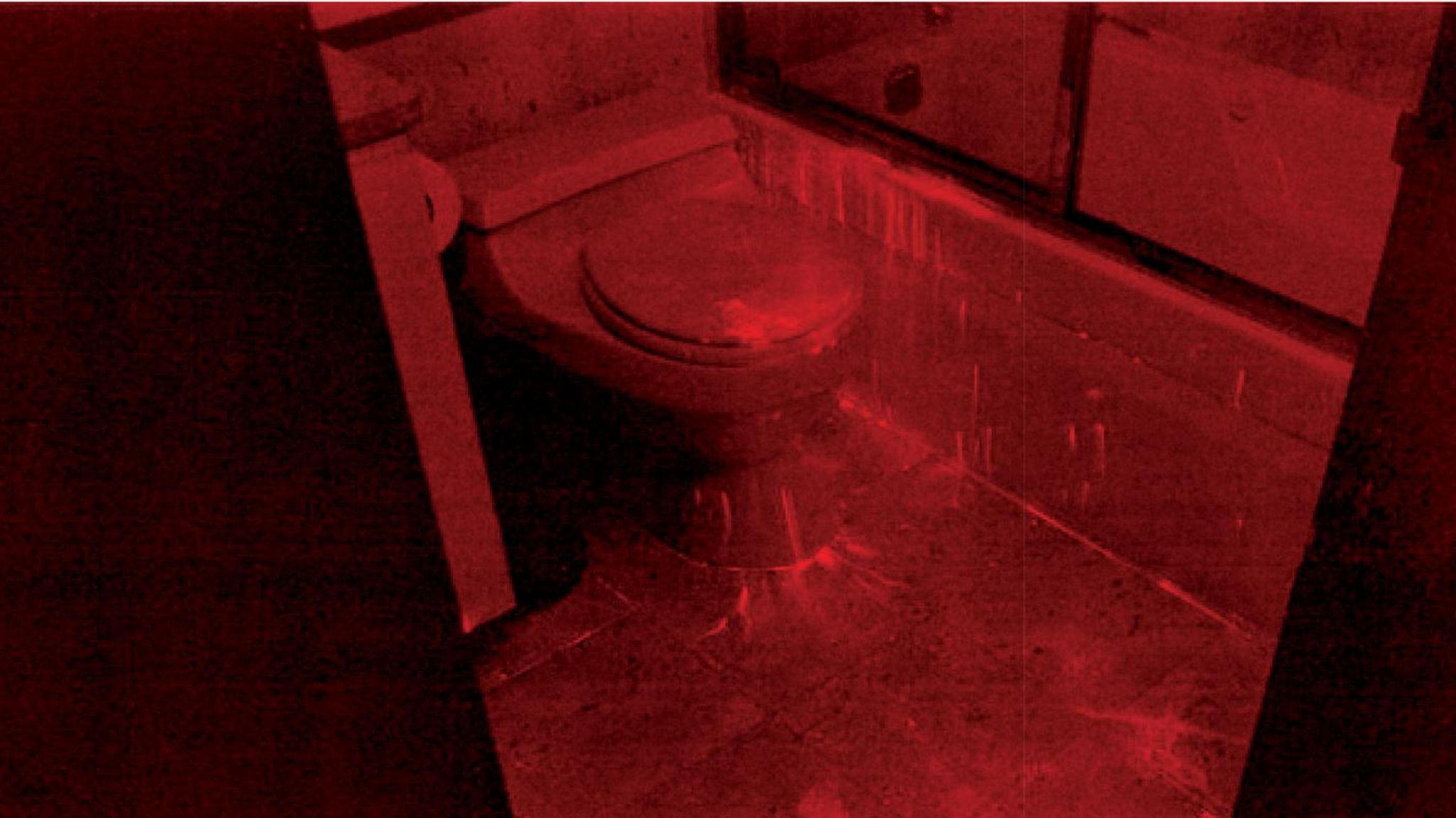 Foto einer Toilette nach der Spurensicherung. Das Bild ist rot eingefärbt
