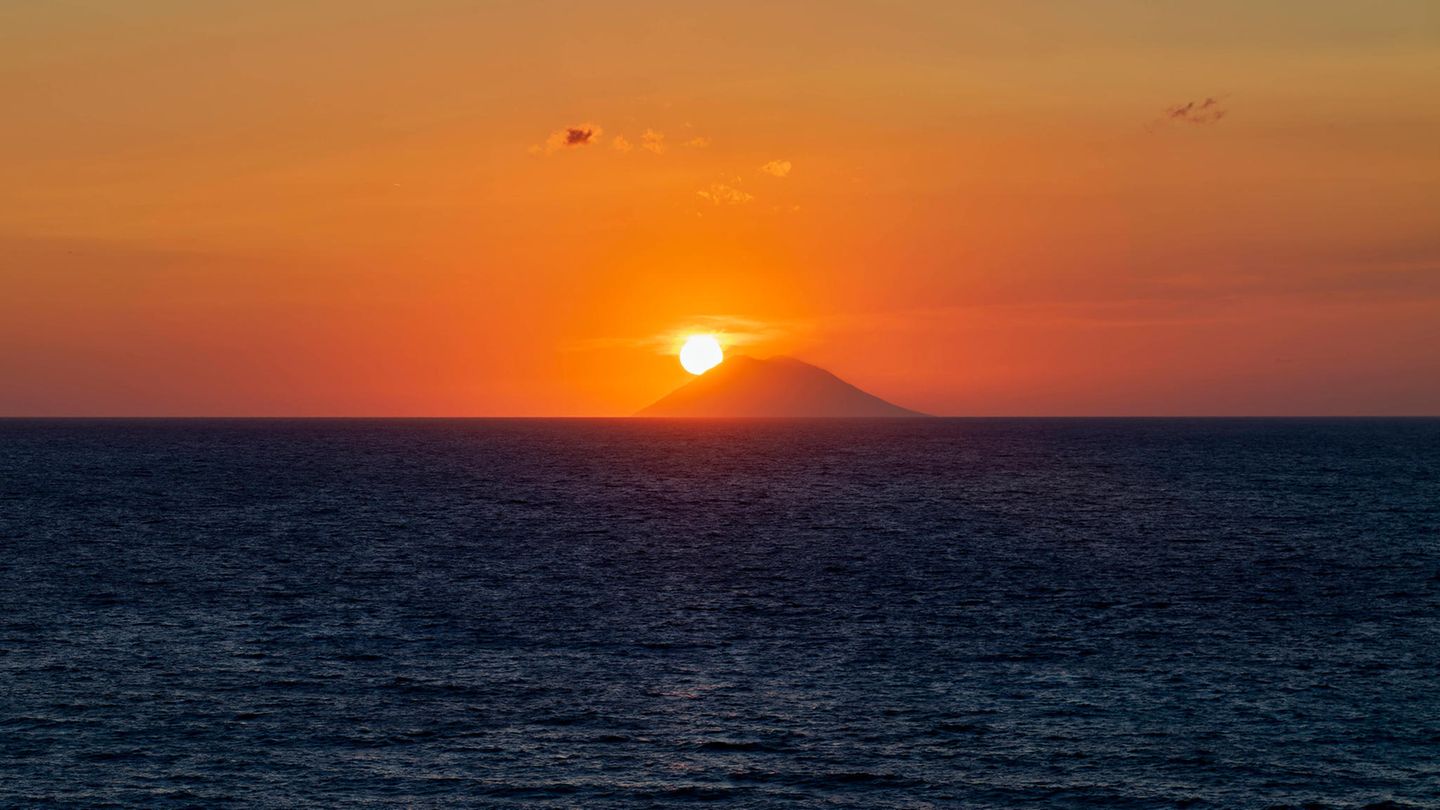 Die Sonne versinkt hinter dem italienischen Vulkan Stromboli