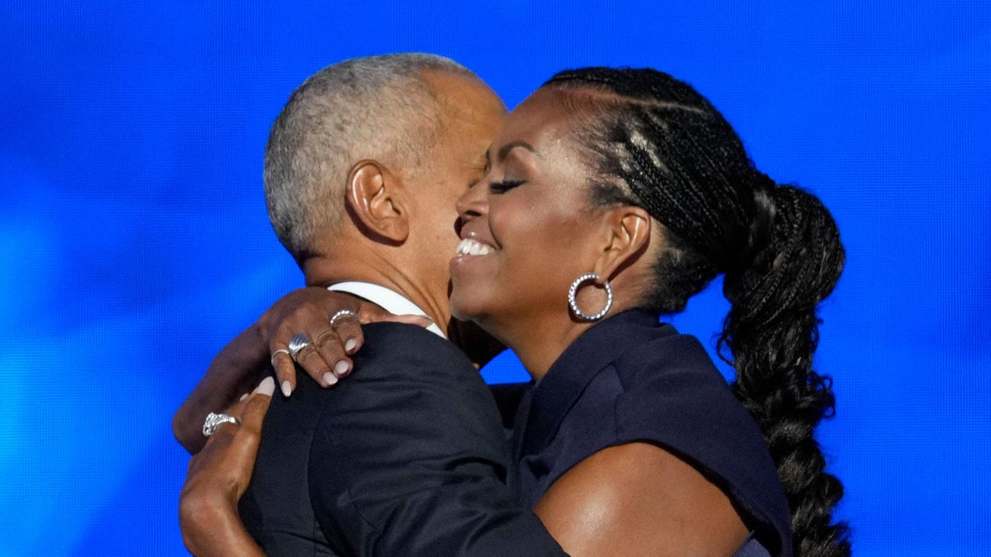 Michelle und Barack Obama umarmen sich auf der Bühne