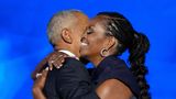 Michelle und Barack Obama umarmen sich auf der Bühne