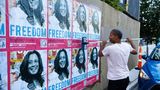 Jemand plakatiert Freedom-Plakate mit dem Konterfei von Kamala Harris
