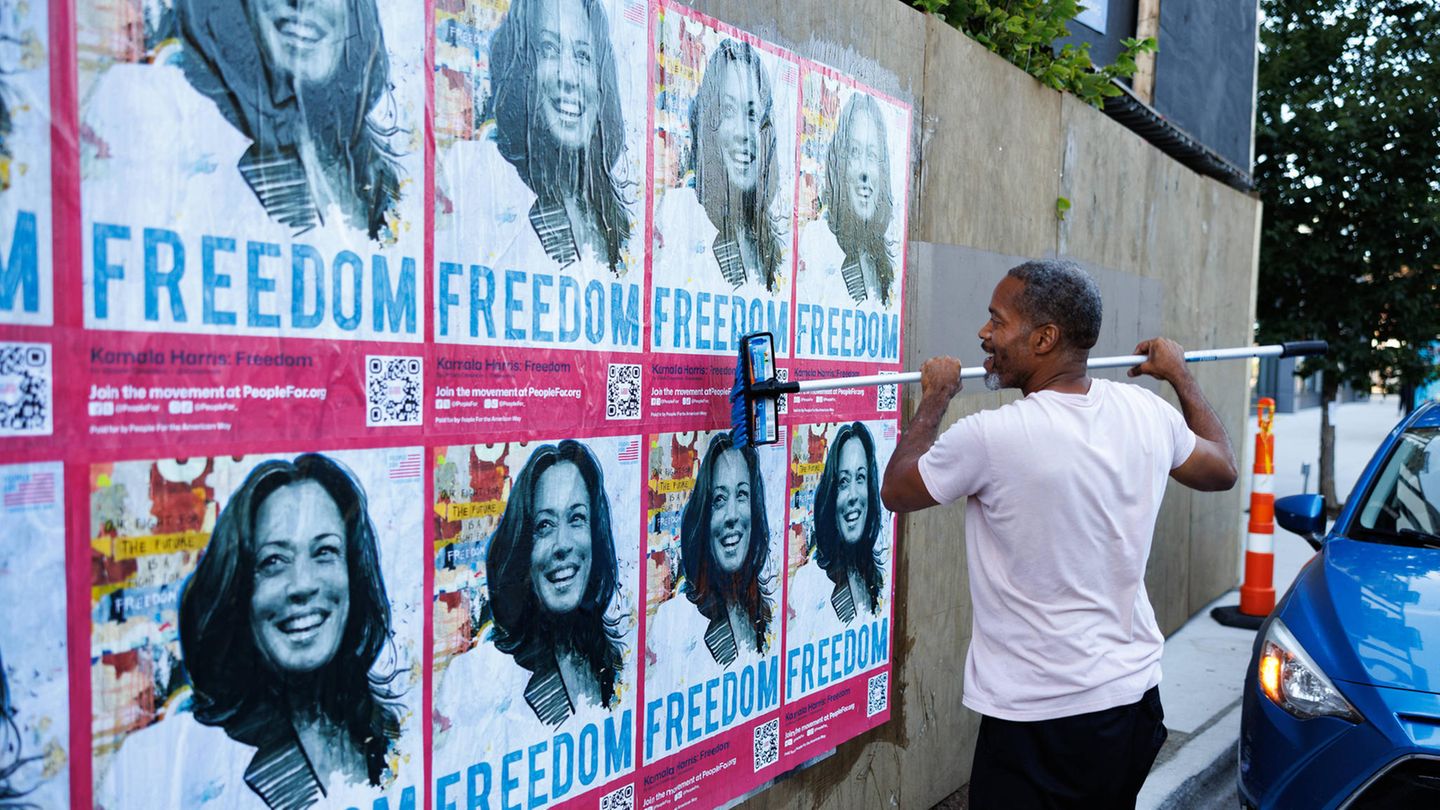 Jemand plakatiert Freedom-Plakate mit dem Konterfei von Kamala Harris