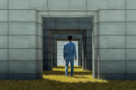Rückansicht eines Mannes im Pyjama, der in einem Beton-Torbogen steht