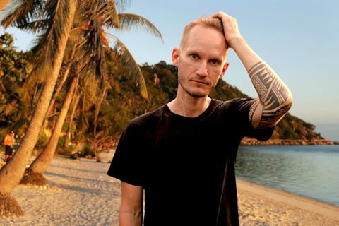 Ein junger Mann steht an einem tropischen Strand in Thailand
